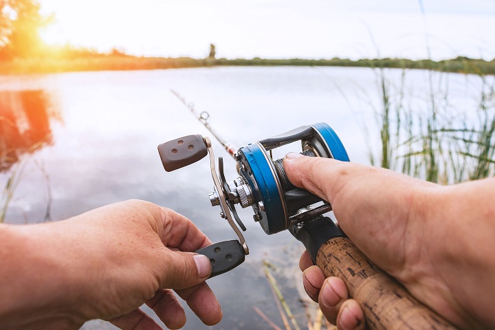 Man is fishing with a backcasting reel