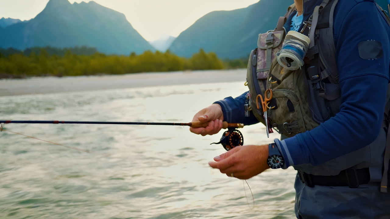 Angler fly fishing in a mountain river with a backpack vest
